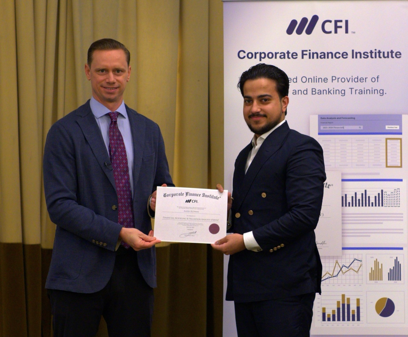 A CFI graduate receiving their printed FMVA certificate from CEO Tim Vipond